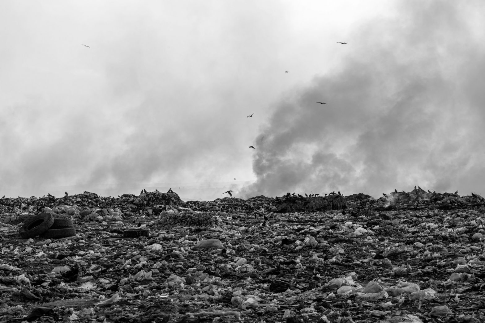 Pollution concept, Burning garbage pile in trash dump or landfill, black and white photo